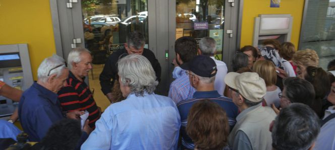 Pensionistas hacen cola para retirar dinero a la entrada de una sucursal bancaria en Salónica, Grecia.