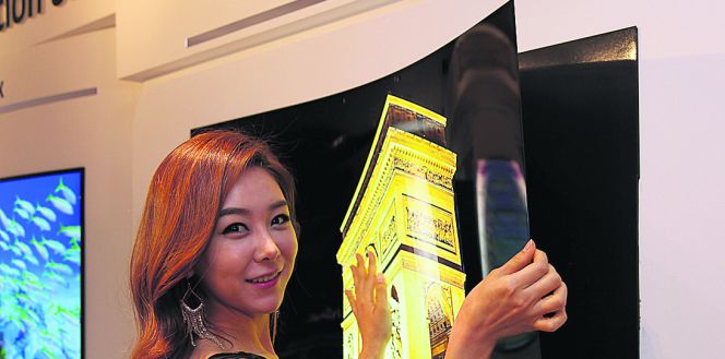Una azafata muestra el televisor de 55 pulgadas enrollable de LG, que la compañía planea llevar al próximo IFA de Berlín.