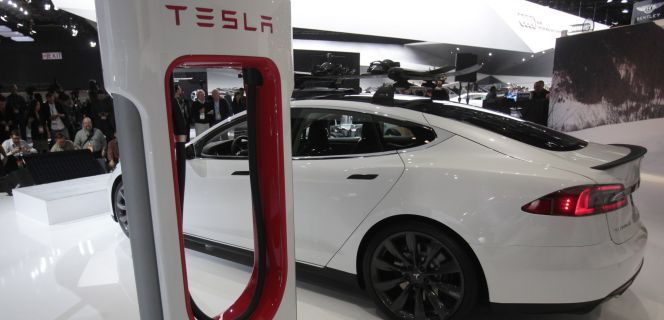 Un Tesla Model S junto a su cargador