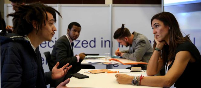 Jóvenes universitarios realizan entrevistas de trabajo en un congreso de empleo juvenil en Barcelona.