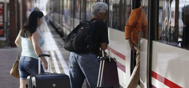 Varias personas montan a un tren en la estación de Chamartín, en Madrid.