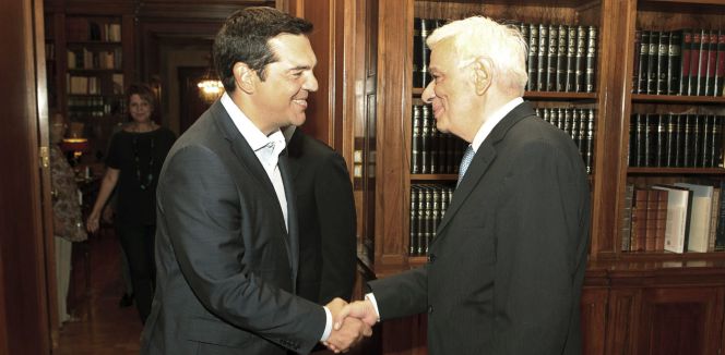 El primer ministro griego, Alexis Tsipras, estrecha la mano del presidente griego, Prokopis Pavlopoulos, tras anunciar su dimisión.