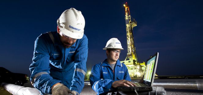 Trabajadores de Schlumberger junto a una plataforma petrolífera.