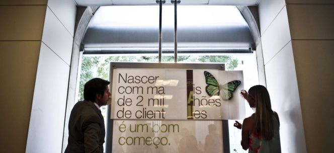 Dos trabajadores cambian el nombre y carteles del Banco Espírito Santo tras la transformación en Novo Banco, en una oficina de Lisboa (Portugal). EFEArchivo