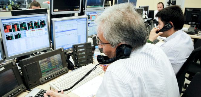 Los agentes de Ahorro Corporación, grupo de servicios financieros encargado de la subasta de bonos y letras del Tesoro Público.