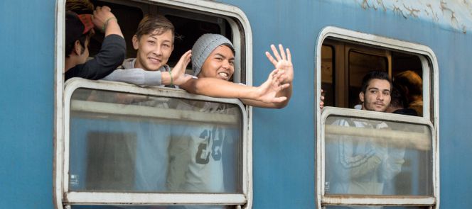 Un grupo de refugiados saluda desde un tren que parte desde Budapest (Hungría), con destino Austria.