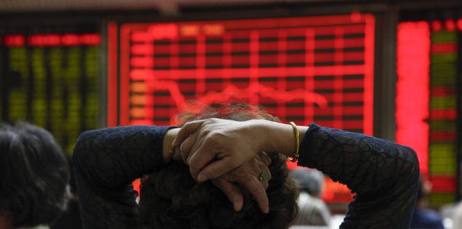 Una mujer comprueba la evolución de la bolsa de Shanghái (China).