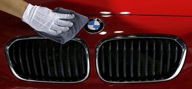 Un operario limpia un modelo de BMW en una feria en China.