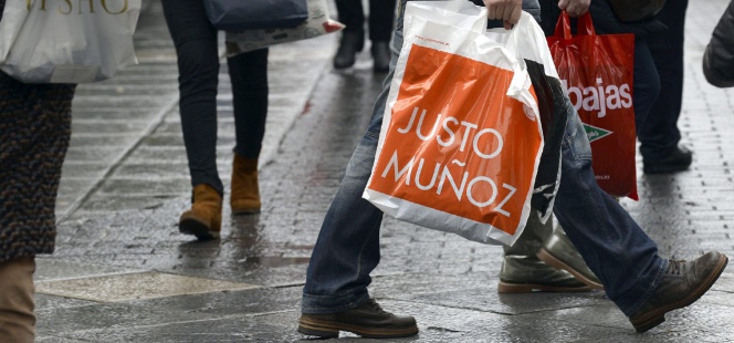 Un grupo de personas camina con bolsas de diversos establecimientos el primer día de rebajas en Valladolid.