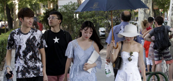 Unas turistas tratan de protegerse del sol en las cercanias del Museo del Prado en Madrid.