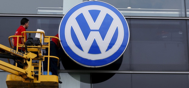 Obreros limpian la fachada del concesionario de Volkswagen en Sevilla.