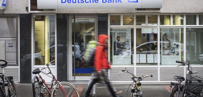 Peatones caminan junto a una sucursal de Deutsche Bank en Fráncfort (Alemania).