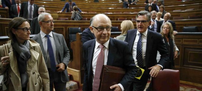 El ministro de Hacienda, Cristóbal Montoro (c), se dispone a salir del hemiciclo al finalizar hoy el pleno del Congreso en el que se han aprobado definitivamente los presupuestos generales del Estado para 2016.
