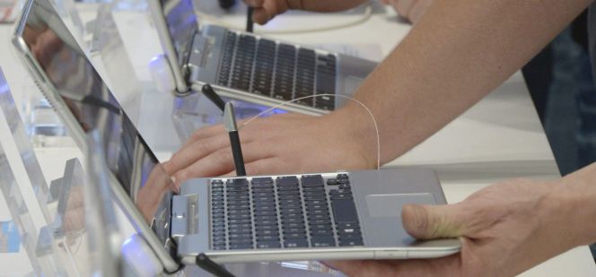 Visitantes prueban portátiles durante la Feria Internacional de la Electrónica.