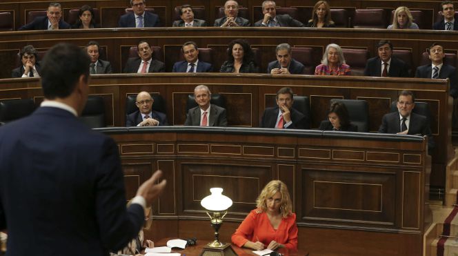 El presidente del Gobierno, Mariano Rajoy (d), escucha la intervención del líder del PSOE, Pedro Sánchez (i, de espaldas), durante la última sesión de control al Gobierno. EFE
