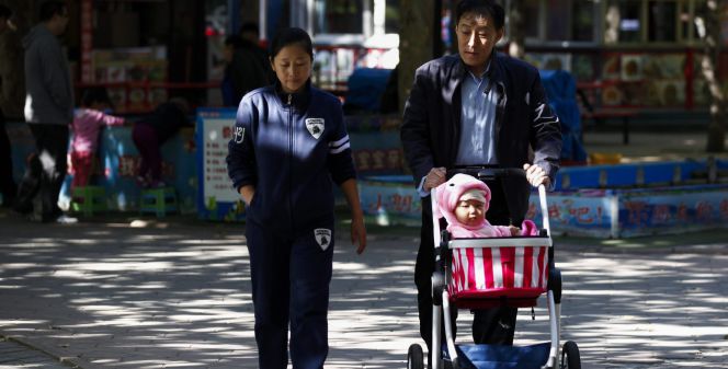 Un abuelo pasea con su nieto y su hija por un parque de Pekín (China).