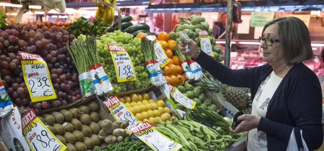 En la imagen, una mujer hace su compra en una frutería del mercado Maravilla en Madrid.