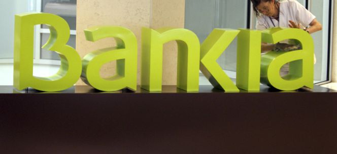Una operaria limpia el logo de Bankia en la sede central de Bancaja. EFEArchivo