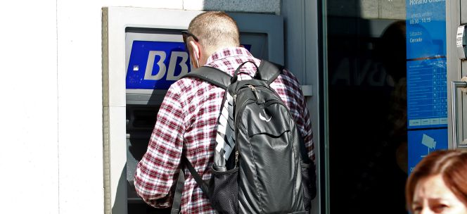 Un cliente sacando dinero de un cajero de BBVA