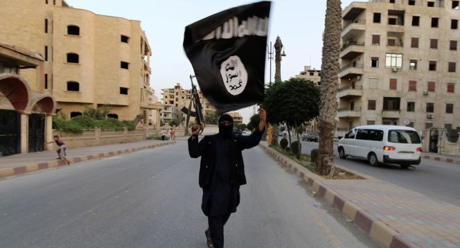 Un miembro de Daesh muestra una bandera del Estado Islámico en Raqqa, en una fotografía de archivo.