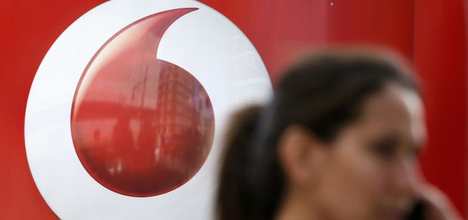 Una mujer al teléfono delante de una tienda de Vodafone en Londres.