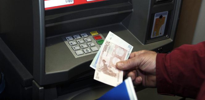 Un hombre retira euros de un cajero automático.