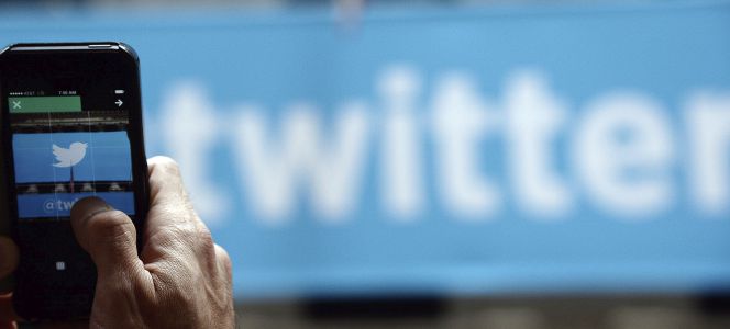 Un usuario toma una fotografía con su teléfono del logotipo de Twitter.