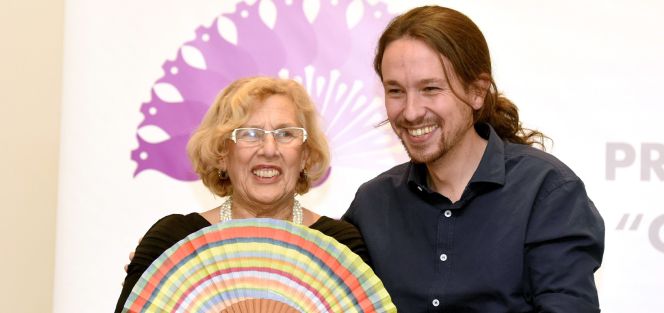La exjuez Manuel Carmena (i), alcaldesa de Madrid, recibe de manos de Pablo Iglesias (d), secretario general de Podemos, uno de los premios anuales que concede El Club de las 25, una asociación de mujeres feministas y progresistas, durante un acto celebrado esta noche en el Hotel Palace.