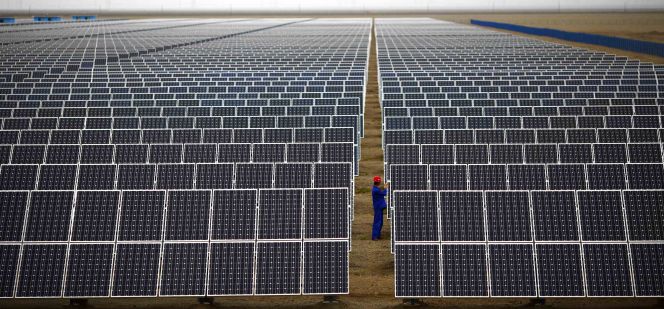 Un operario supervisa un panel solar en una planta de Dunhuang, al noroeste de China.