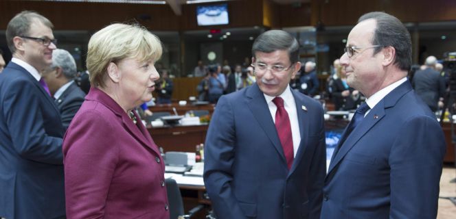 La canciller alemana, Angela Merkel, charla con el primer ministro turco, Ahmet Davutoglu, y el presidente francés, Francois Hollande, en la cumbre extraordinaria sobre la inmigración.