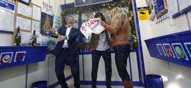 Tres personas celebran el Gordo de la lotería de Navidad en una administración.