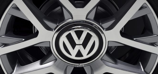 Detalle del logotipo de Volkswagen en la llanta de un coche expuesto en un Salón del Automóvil.