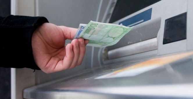 Un hombre saca euros de un cajero automático.