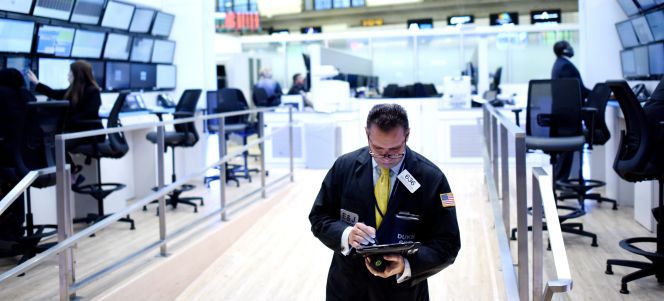 Un corredor bursátil observa una tableta, en el recinto de la Bolsa de Wall Street (Nueva York).