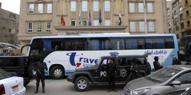 Varios policías vigilan junto a un autobús con una ventanilla dañada tras el ataque a un hotel de varios hombres armados, cerca de las pirámides de Giza, Egipto.