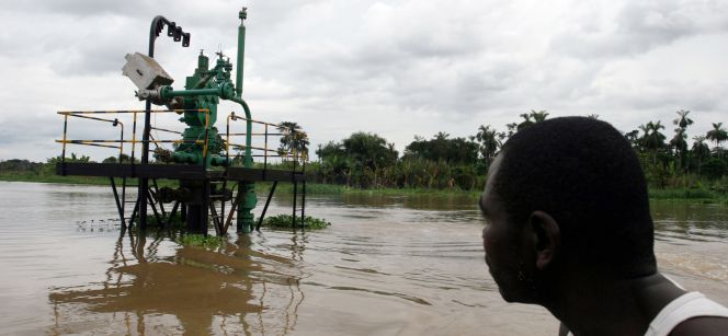 Un hombre observa un pozo de extracción de crudo en el rio Niger (Nigeria).