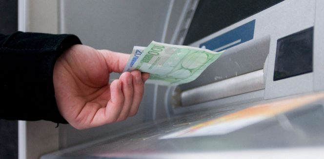 Un hombre saca euros de un cajero automático.