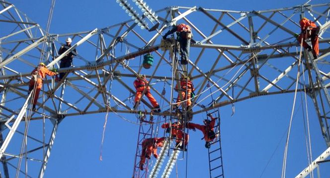 Empleados de Abengoa en una línea de transmisión eléctrica.