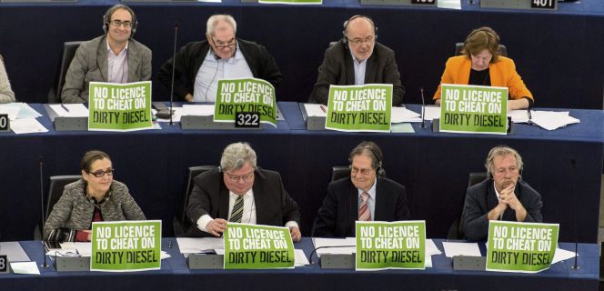 Miembros del partido de Los Verdes sostienen pancartas en protesta por los millones de automóviles diesel trucados