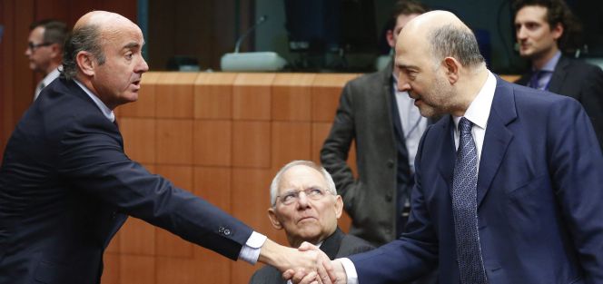 El ministro español de Economía en funciones, Luis de Guindos, estrecha la mano del comisario europeo de Asuntos Económicos y Financieros, Pierre Moscovici.