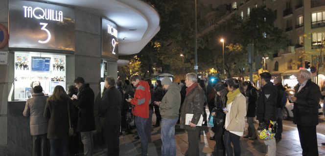 Varias personas hacen cola en la taquilla de un cine en Madrid.
