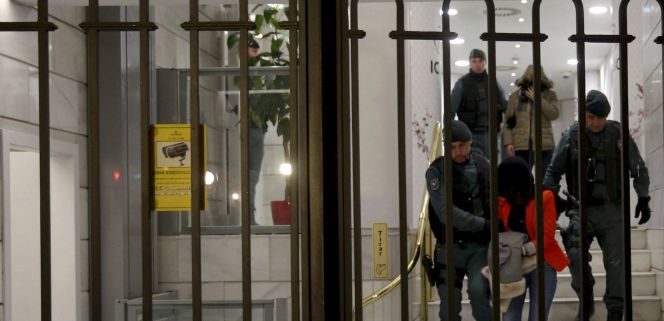 La Guardia Civil escolta a dos de los sospechosos de blanqueo durante el registro en la sucursal madrileña de ICBC.
