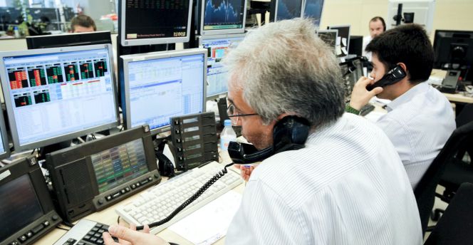 Los agentes de Ahorro Corporación, grupo de servicios financieros encargado de la subasta de bonos y letras del Tesoro Público.