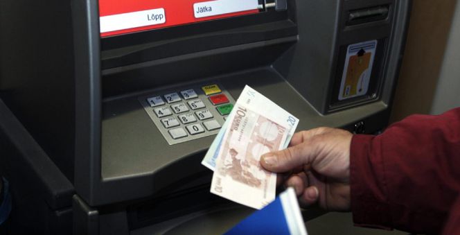 Un hombre retira euros de un cajero automático.