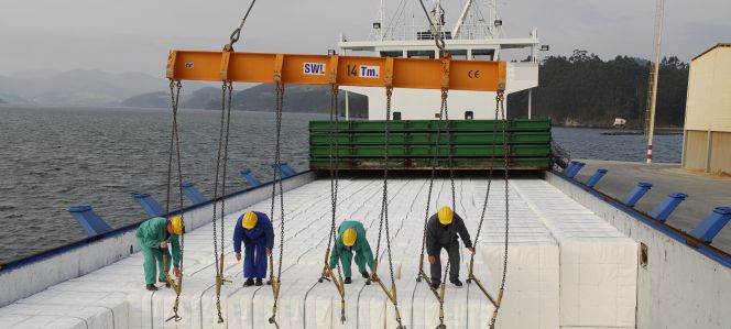Operarios cargando celulosa en un naviero.