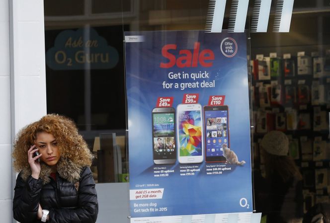 Una persona habla con su mpóvil frente a una tienda de O2 en Reino Unido