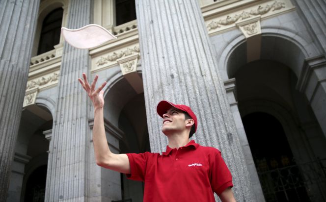 Un empleado de Telepizza en la puerta de la sede de BME en la Plaza de la Lealtad de Madrid.