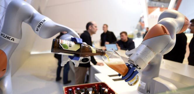 Robots sirven cerveza en un vaso en la Feria industrial celebrada recientemente en Hannover (Alemania).