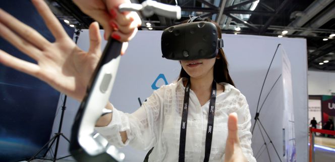 Una joven prueba las gafas de HTC de realidad virtual, una tecnología que impactará en diferentes industrias.