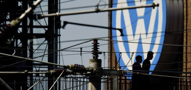 Dos hombres caminan junto al logotipo de Volkswagen en la fábrica de Volkswagen en la sede de Wolfsburgo, cerca de Hannover (Alemania).